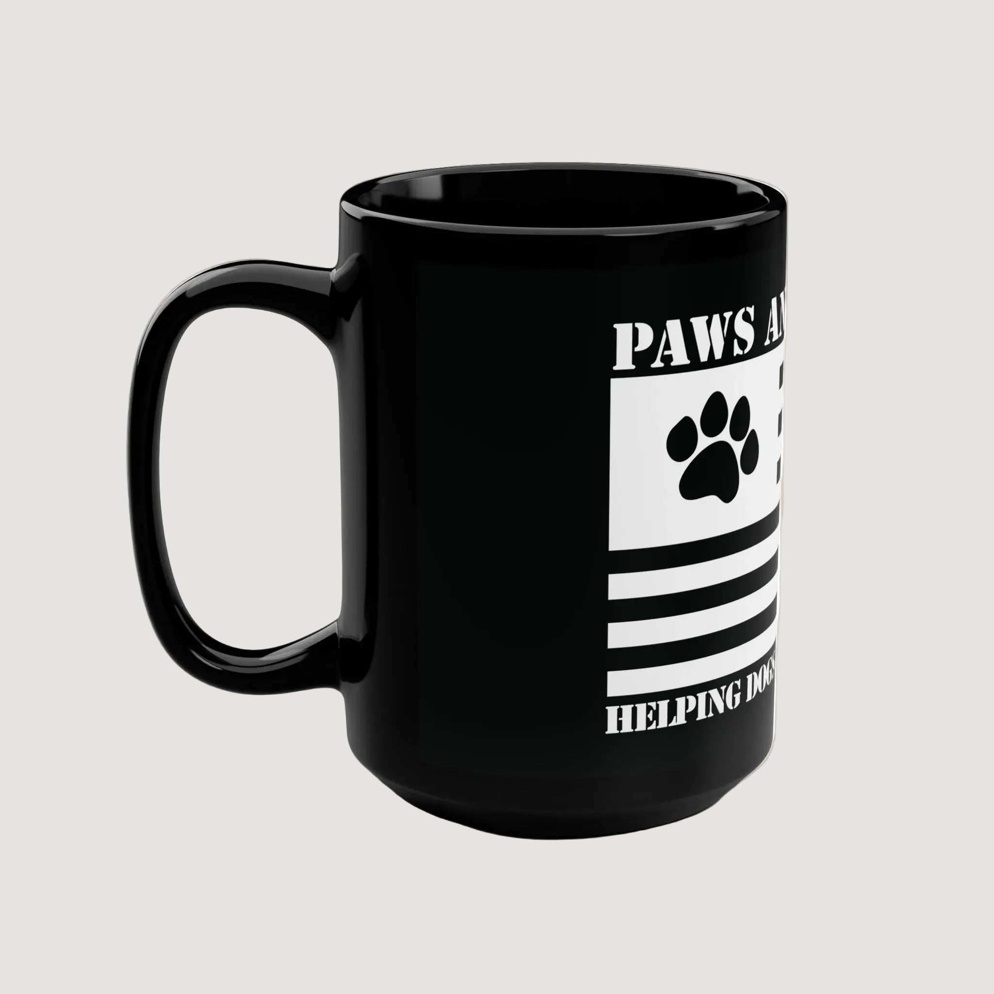 Black mug with paw print design and text on a beige background