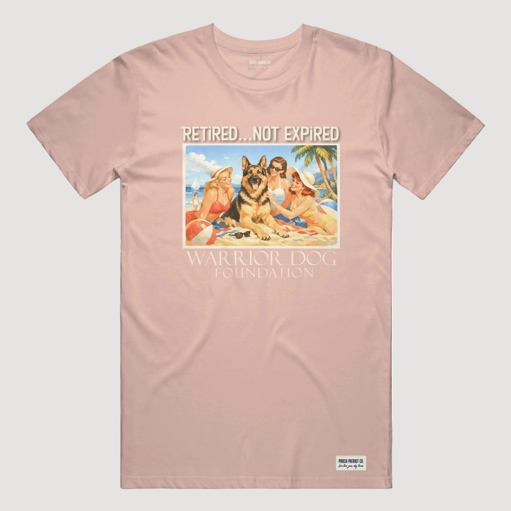 Pink t-shirt with a graphic of two dogs on a beach and text 'Retired... Not Expired' and 'Warrior Dog Foundation'.