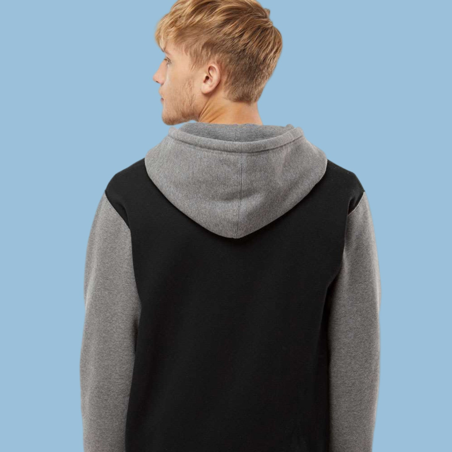 Person wearing a black and gray hoodie with a white background