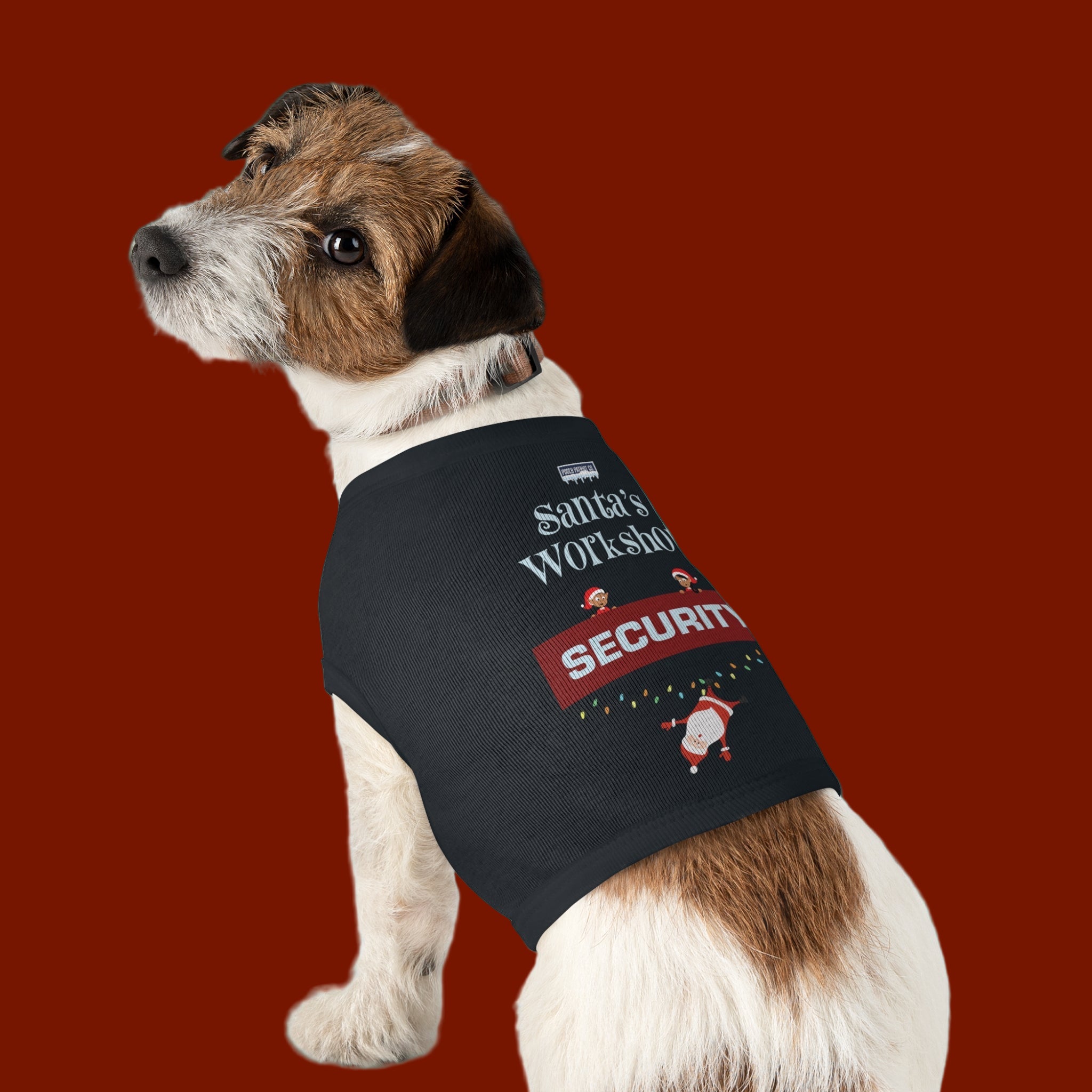Dog wearing a 'Santa's Workshop Security' vest on a green background