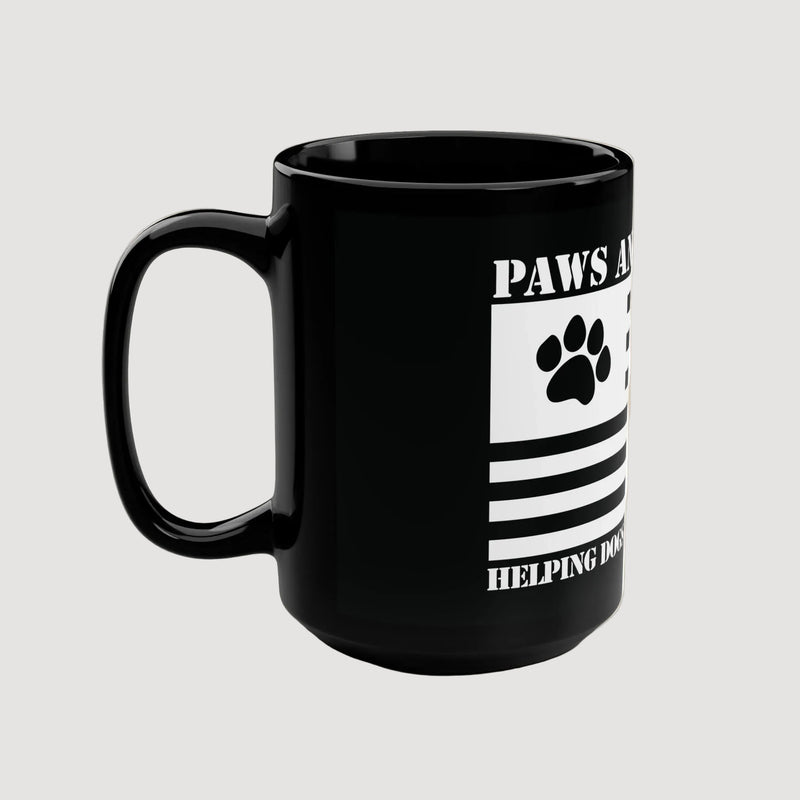 Black mug with paw print design and text on a beige background