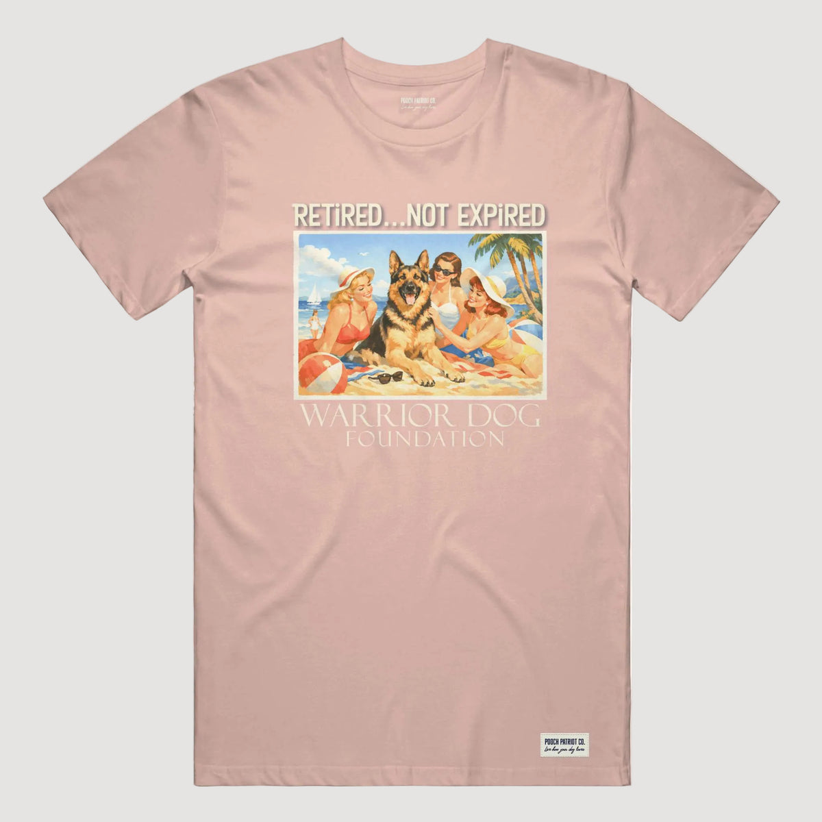 Pink t-shirt with a graphic of two dogs on a beach and text 'Retired... Not Expired' and 'Warrior Dog Foundation'.