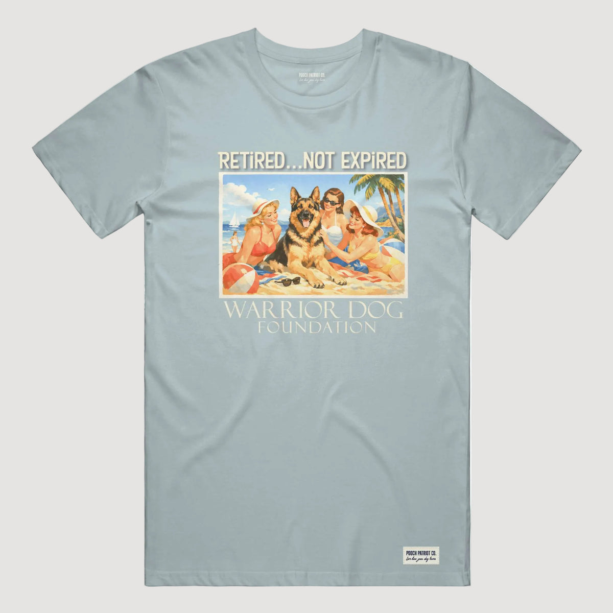 Light blue t-shirt with a graphic of people and dogs on a beach, featuring the text 'Retired.