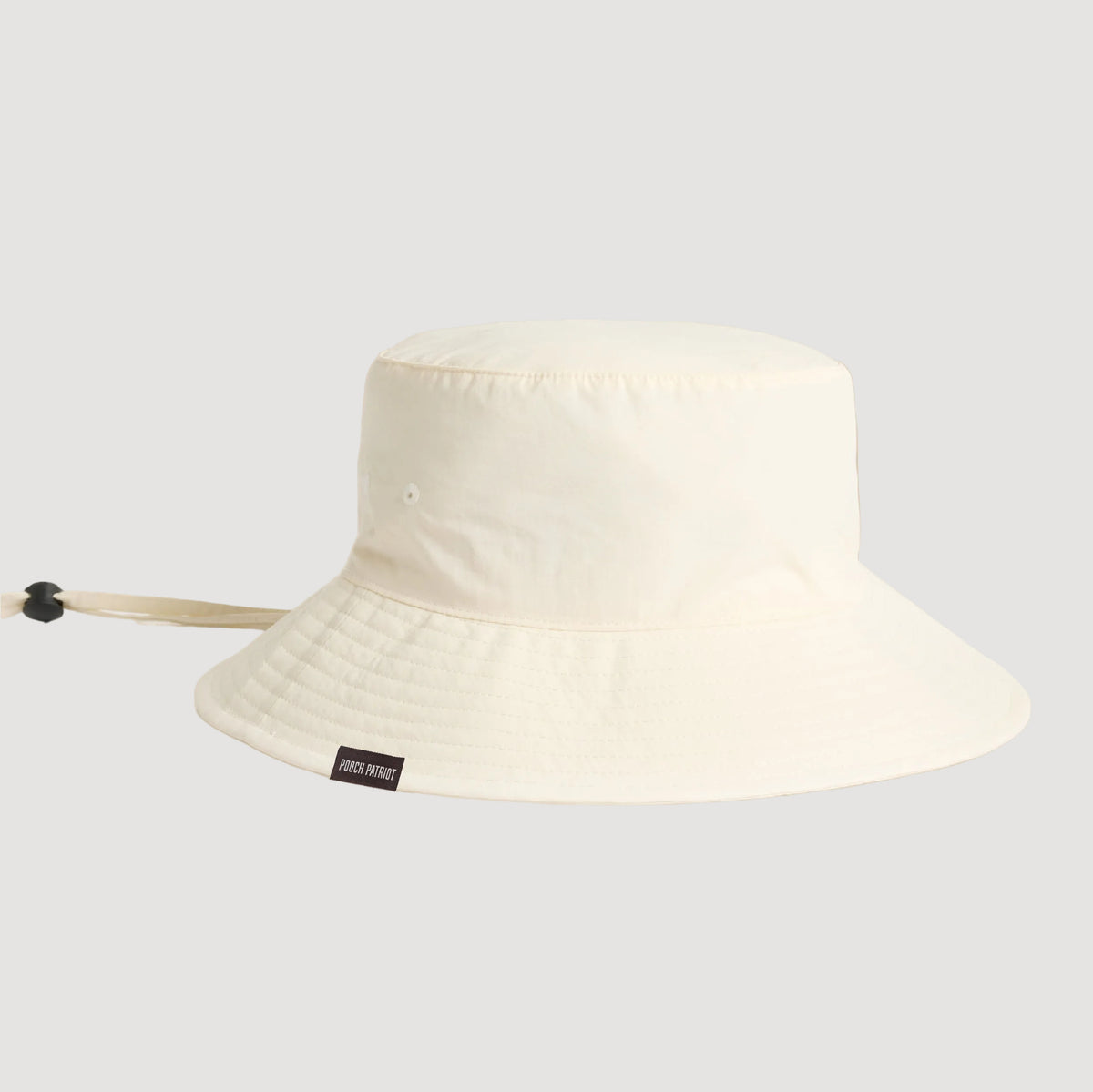 White bucket hat with a brand label on a beige background