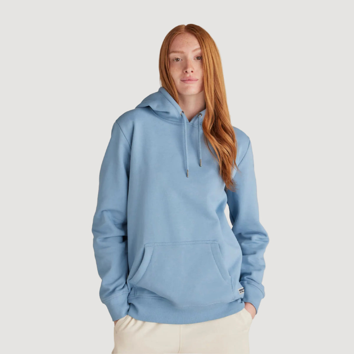 Person wearing a blue hoodie on a beige background