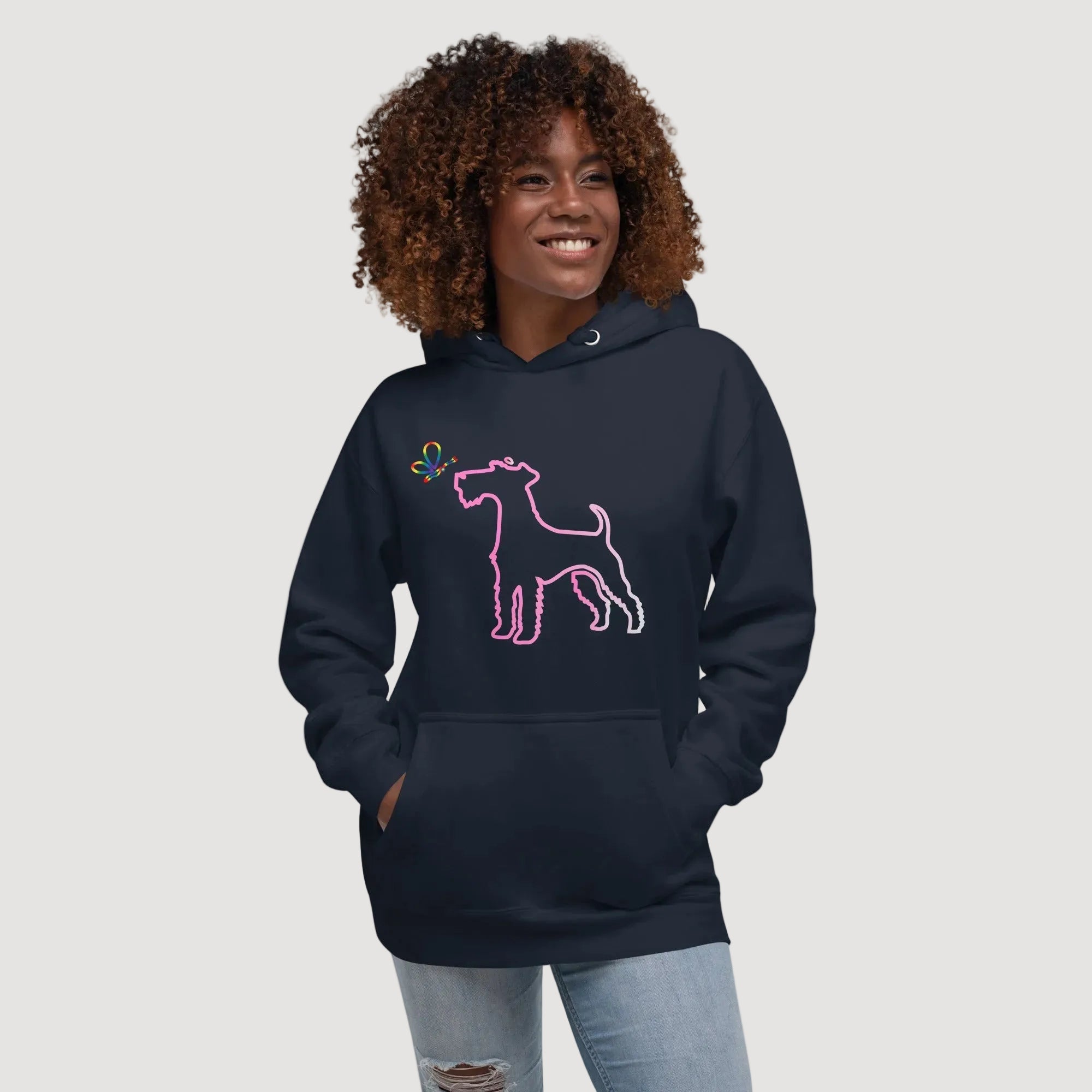 Person wearing a black hoodie with a pink dog design on a beige background